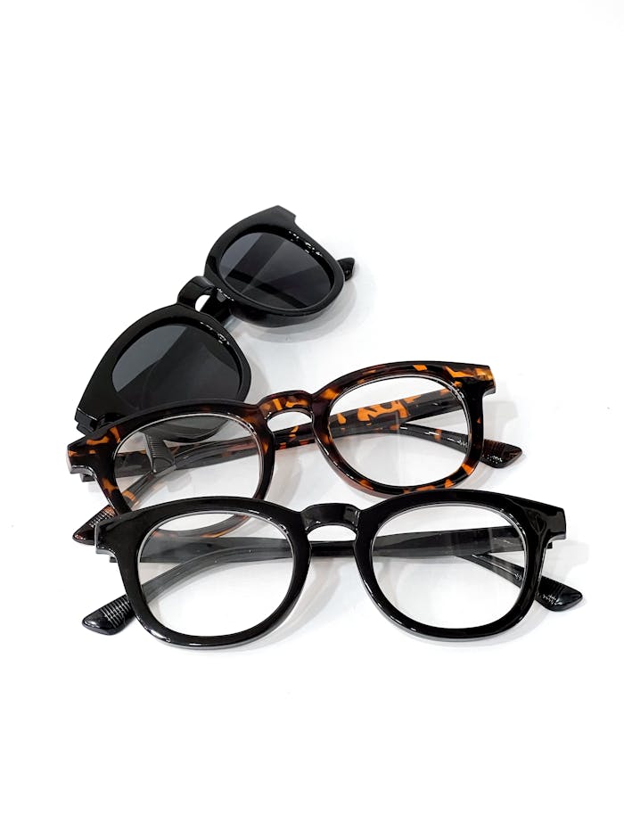 Crafting Captivating Headlines: Your awesome post title goes here Three pairs of fashionable glasses, including tortoiseshell and black frames on a white surface.