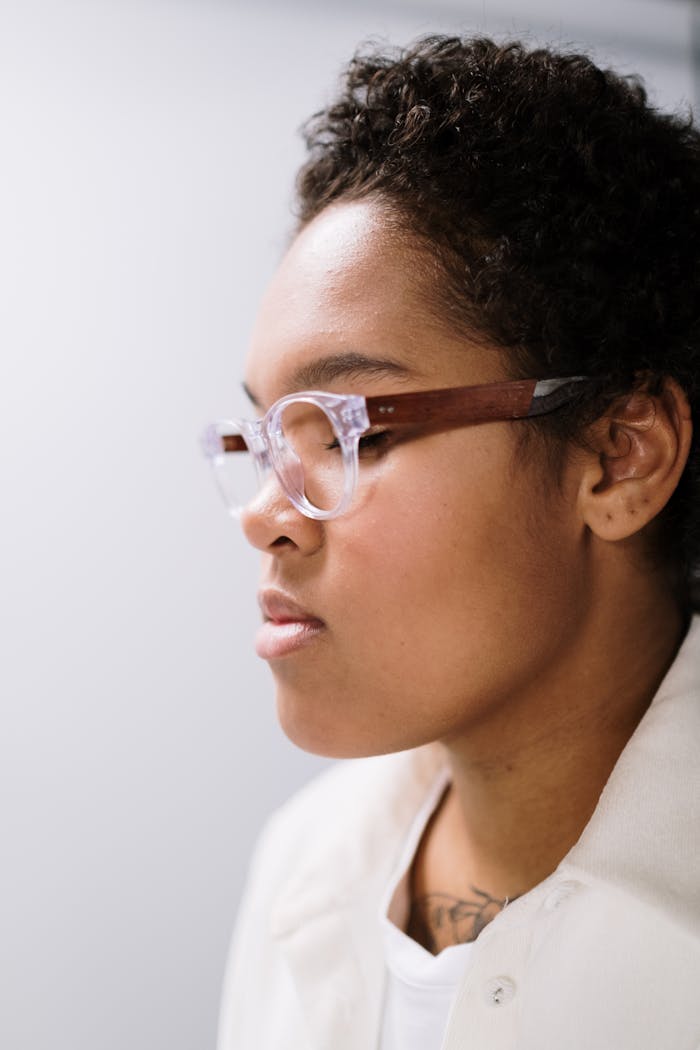 The Art of Drawing Readers In: Your attractive post title goes here Close-up profile of a woman with curly hair wearing glasses indoors.